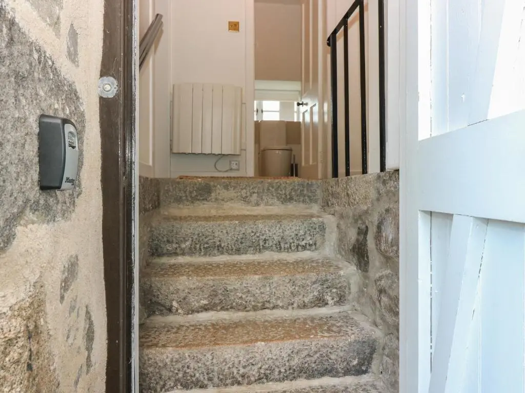 a set of stairs in a hallway with a door at Courtyard Cottage - Drum Castle in Banchory