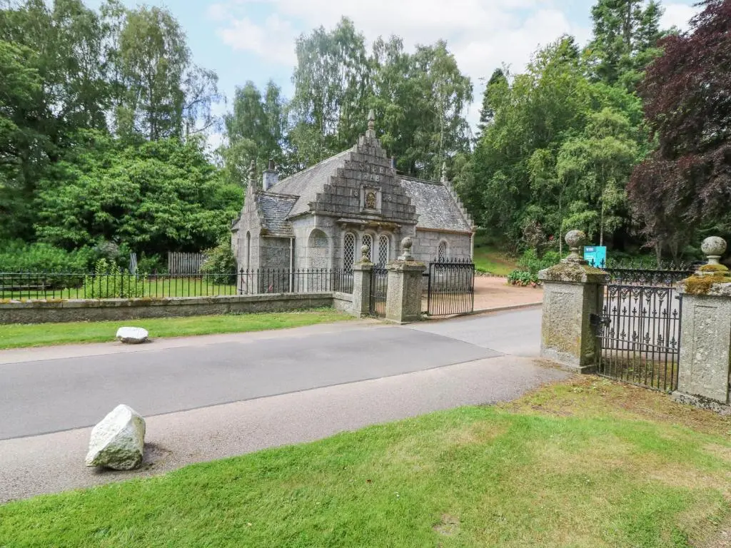 an old house with a gate in a park at East Lodge - Crathes Castle in Banchory