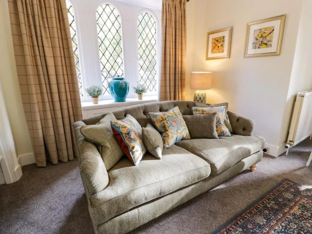 a living room with a couch and two windows at East Lodge - Crathes Castle in Banchory