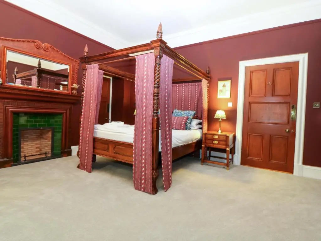 a bedroom with a four poster bed and a mirror at Braeriach - Mar Lodge Estate in Ballater