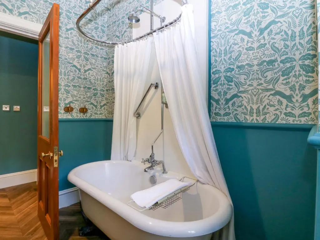 a blue bathroom with a tub and a sink at Braeriach - Mar Lodge Estate in Ballater