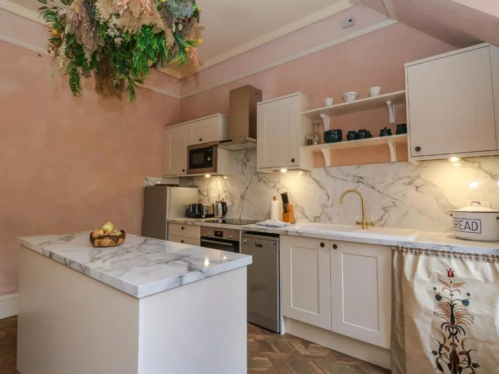 a kitchen with white cabinets and a counter top at Dalvorar - Mar Lodge Estate in Ballater