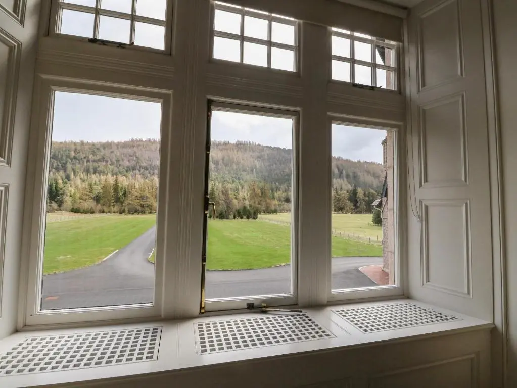an open window with a view of a road at Dalvorar - Mar Lodge Estate in Ballater