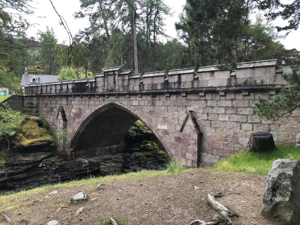 a stone bridge over a river with a road at Macdui - Mar Lodge Estate in Ballater