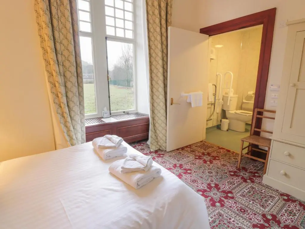 a bedroom with a bed with two towels on it at Bynack - Mar Lodge Estate in Ballater