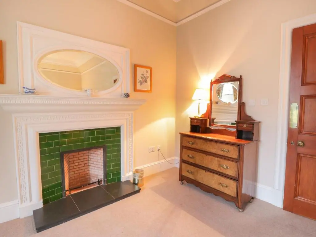 a room with a fireplace with a mirror and a dresser at Bynack - Mar Lodge Estate in Ballater