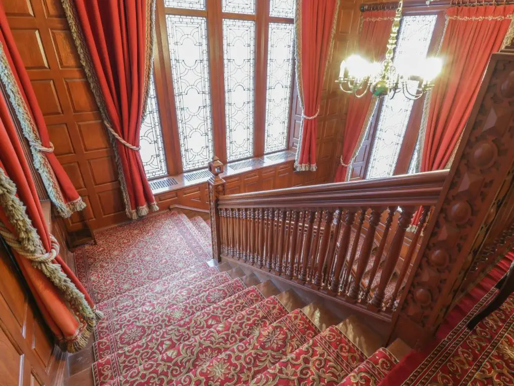 a staircase in a house with red curtains and a window at Bynack - Mar Lodge Estate in Ballater