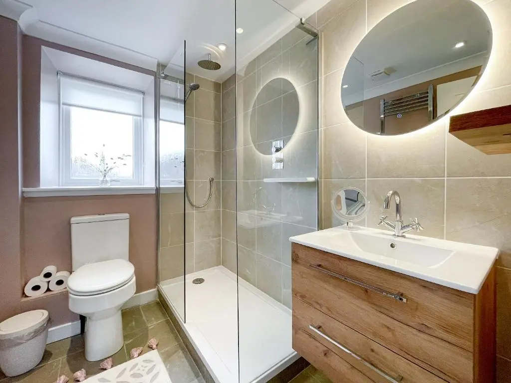 a bathroom with a toilet and a sink and a shower at The Grain Store in Aberarder