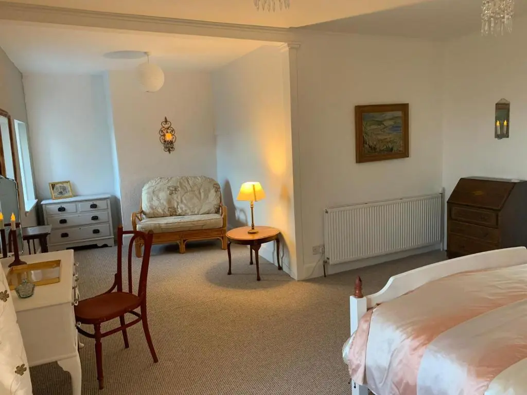 a bedroom with a bed and a chair and a table at Hill House - Mews Town House, in a quiet private close, in the City Centre of Inverness. in Inverness