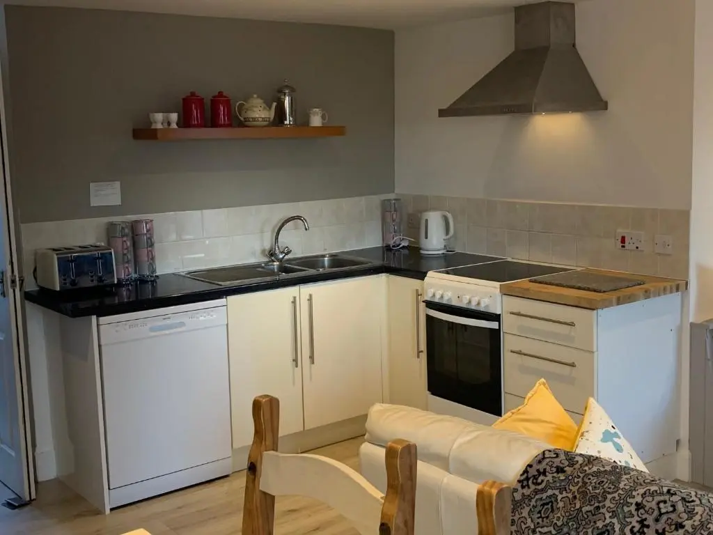 a kitchen with a sink and a stove top oven at Hill House - Mews Town House, in a quiet private close, in the City Centre of Inverness. in Inverness