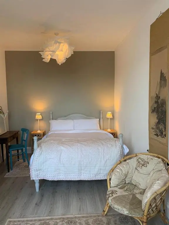 a bedroom with a white bed and two chairs at Hill House - Mews Town House, in a quiet private close, in the City Centre of Inverness. in Inverness