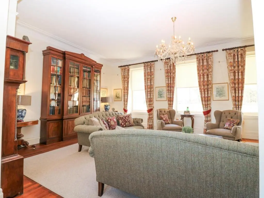 a living room with a couch and chairs and a chandelier at North Wing - Pitmedden Gardens in Ellon