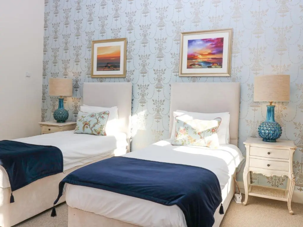 two beds in a bedroom with blue and white walls at North Wing - Pitmedden Gardens in Ellon