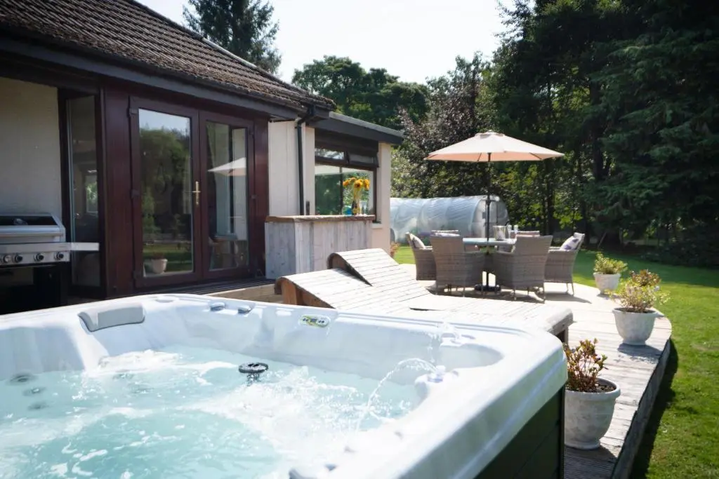 a jacuzzi tub in the backyard of a house at Kinloch Lodge in Bearnock