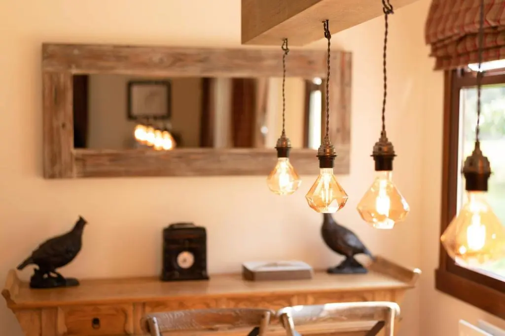 a room with a table with lights and a mirror at Kinloch Lodge in Bearnock
