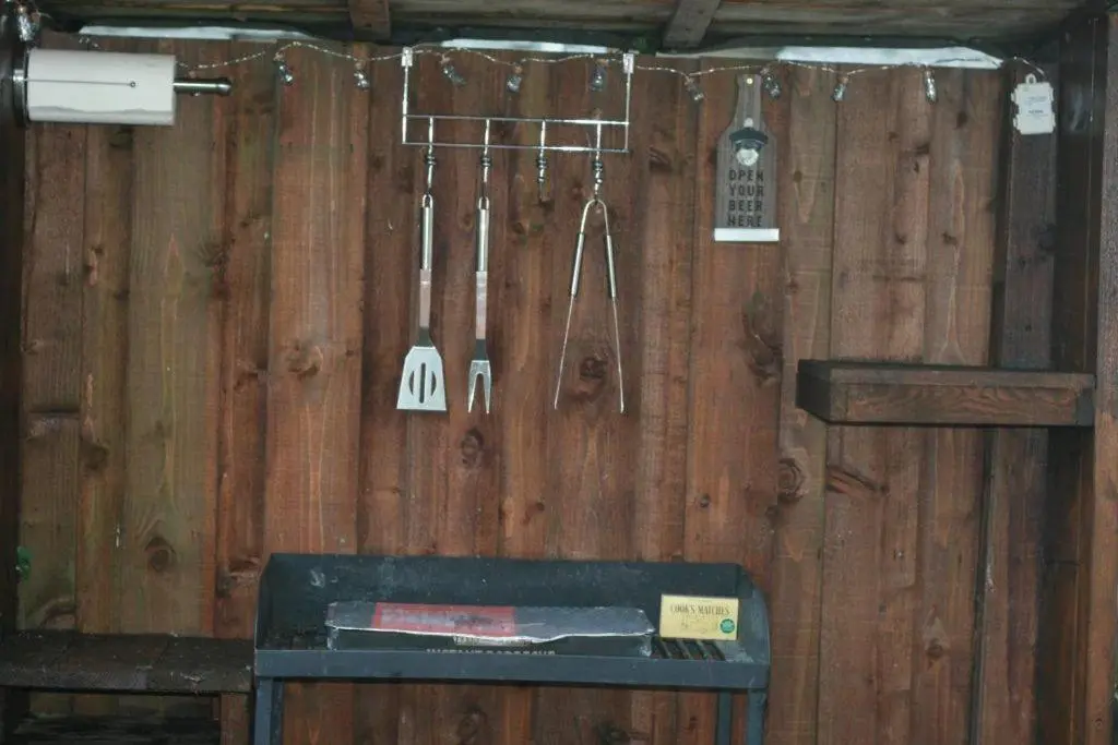 a wooden wall with utensils hanging on it at Red Squirrel Lodge in Boat of Garten