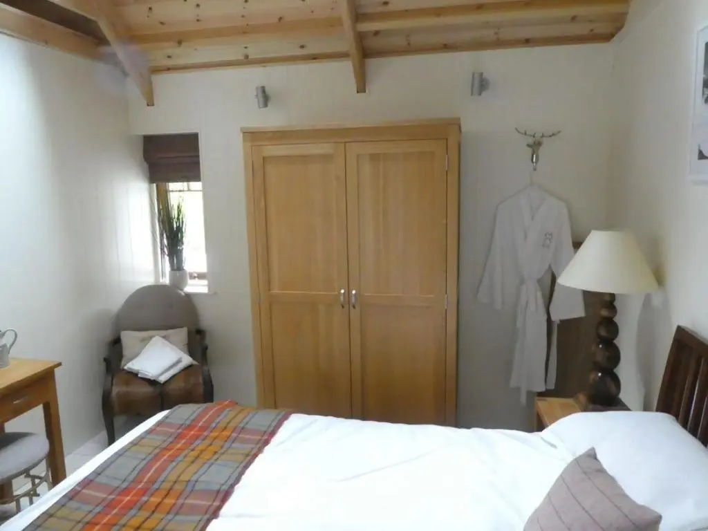 a bedroom with a bed and a closet and a dresser at Wildcat Lodge in Boat of Garten
