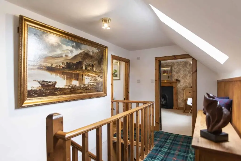 a painting hanging on a wall in a room at Rowan Cottage in Aviemore