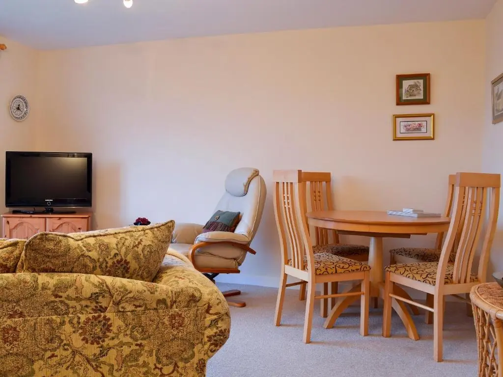 a living room with a couch and a table and chair at Brae Lodge in Cullen