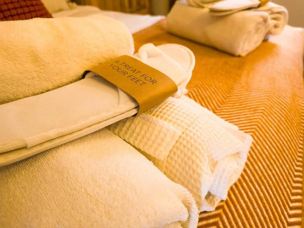 a pile of towels sitting on top of a bed at The Maltings - lodge with hot tub in Nethy Bridge