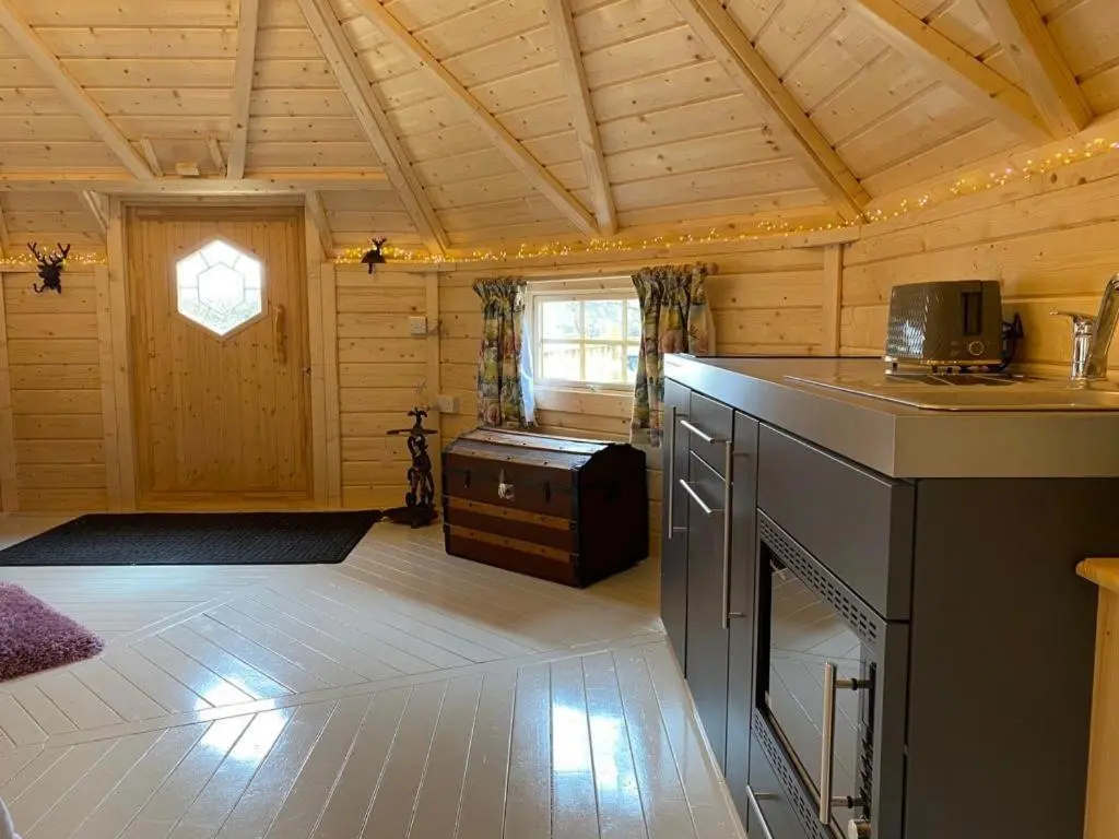 a room with a kitchen and a living room at Woodland Lodge Mither Tap in Kintore