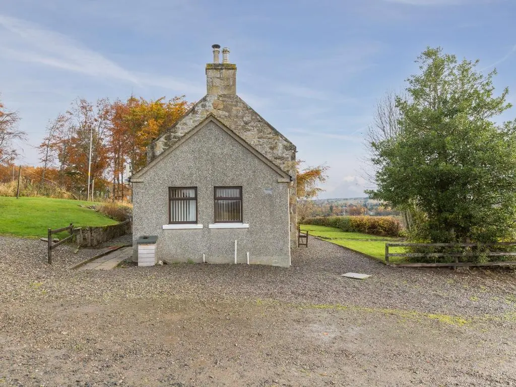 a small gray building with a chimney on top at Balnain 1 in Cononbridge