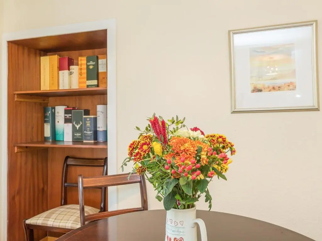 a vase of flowers sitting on top of a table at Balnain 1 in Cononbridge