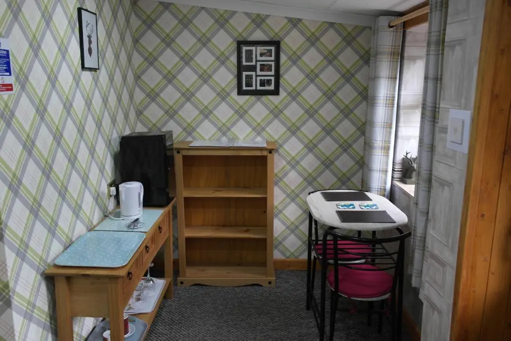 a room with a desk and a table and a deskablish at The Steading Highland Glen Lodge in Drumnadrochit