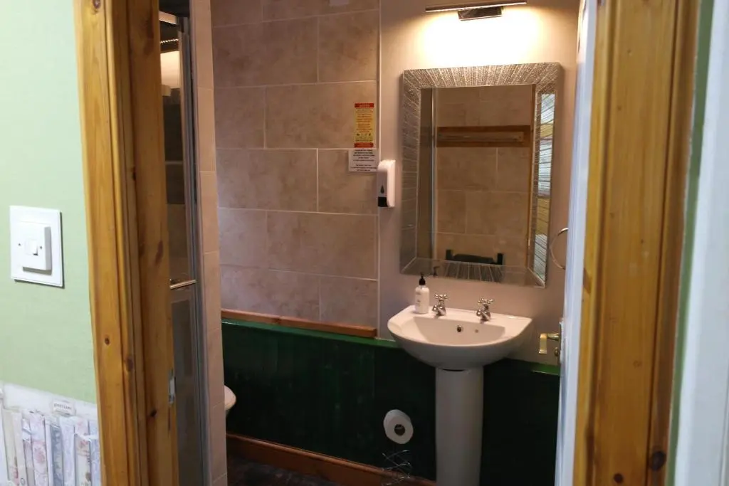 a bathroom with a sink and a mirror at The Steading Highland Glen Lodge in Drumnadrochit