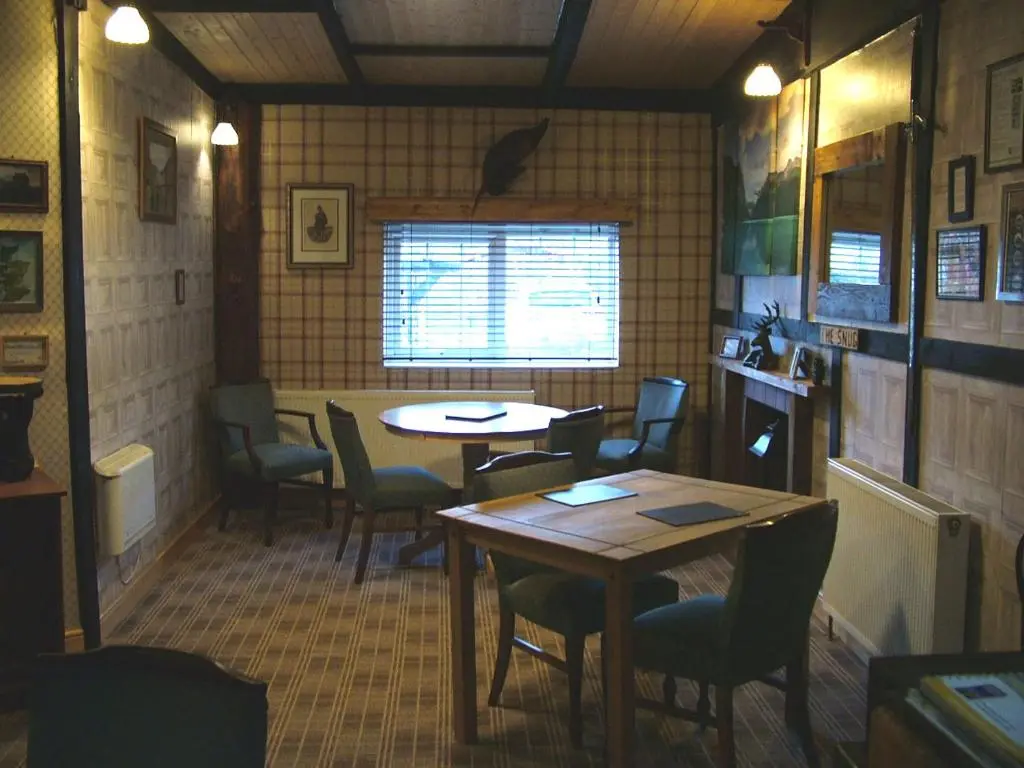 a restaurant with tables and chairs in a room at The Steading Highland Glen Lodge in Drumnadrochit