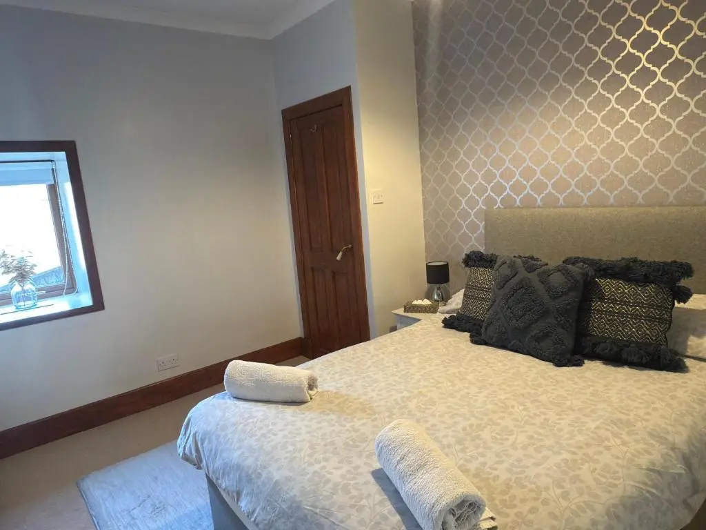 a bedroom with a bed with two towels on it at Newly Refurbished 2 Bedroom flat on NC500 route in Wick