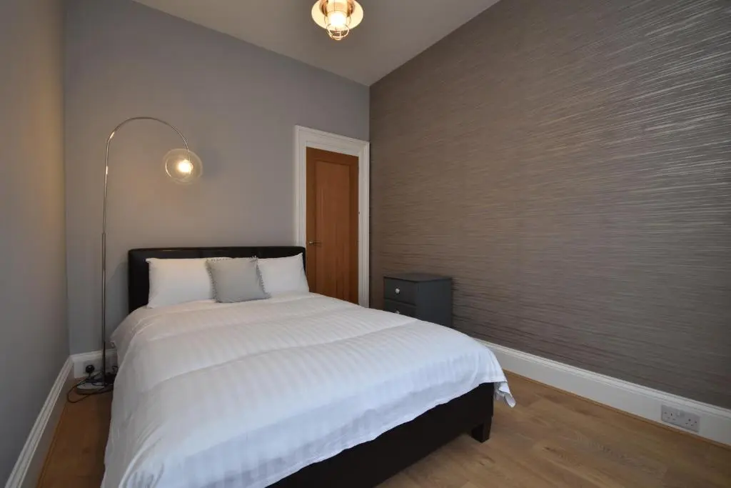 a bedroom with a large white bed in it at Signature Apartments in Fraserburgh