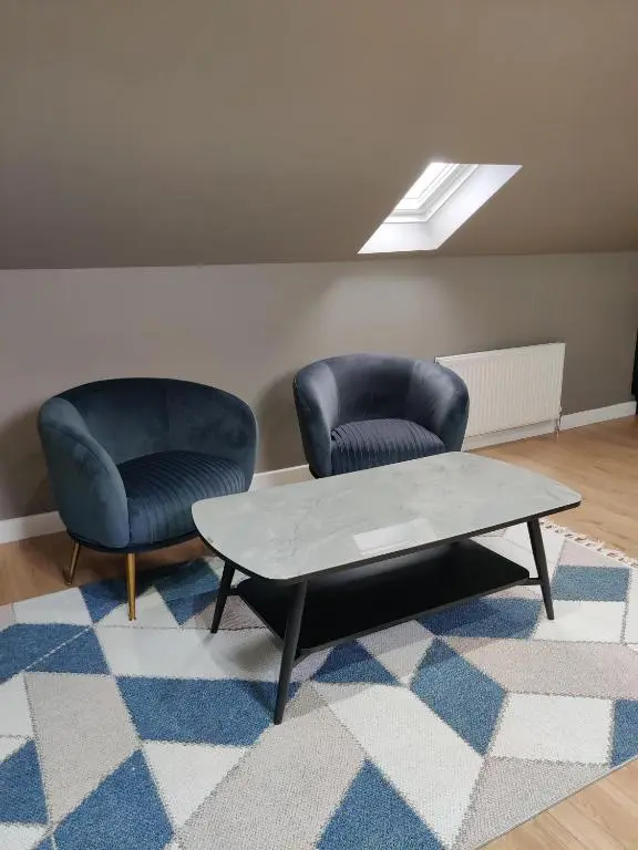 two chairs and a coffee table in a room at Signature Apartments in Fraserburgh