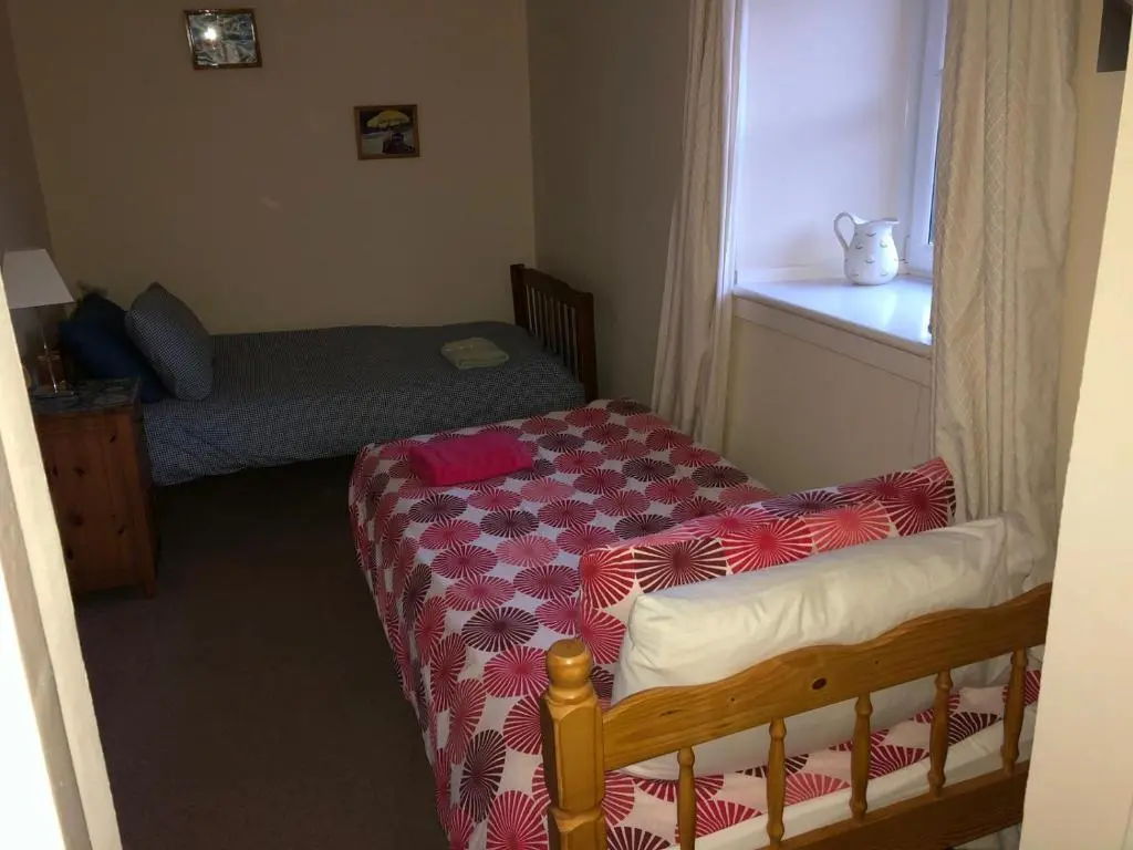 a small bedroom with a bed and a window at PetFriendly-Beachfront-SunsetFacingSunPorch-Garden in Portmahomack