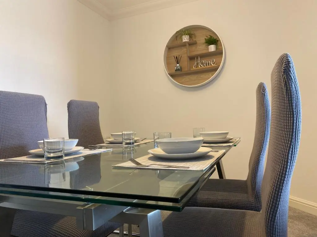 a dining room with a glass table and chairs at The Duplex Nairn- Spacious 3 Bedroom with sunny balcony in Nairn