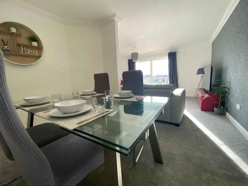 a dining room with a glass table and chairs at The Duplex Nairn- Spacious 3 Bedroom with sunny balcony in Nairn