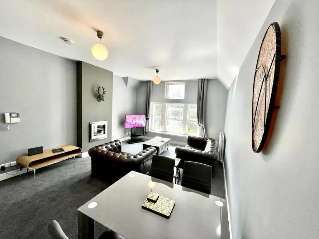a living room with a couch and a table at Serviced Accommodation Moray - Lesmurdie House in Elgin