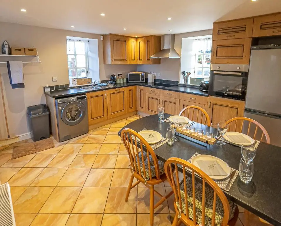 a kitchen with a table and chairs and a stove at The Barley Mill in Elgin