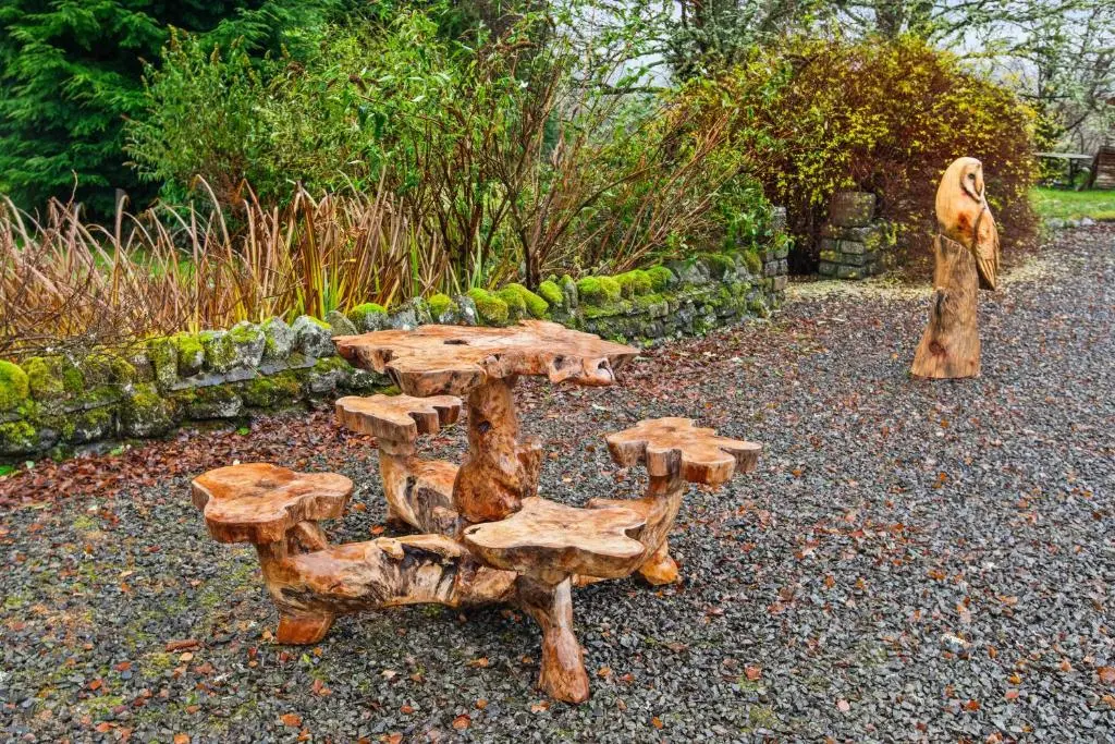 a wooden table and chairs in a garden at Freuchies Mill - A Holiday Home For All Seasons. in Blairgowrie