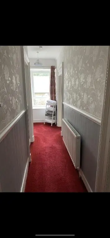 a hallway with a red carpet and a window at NC500, Wick Caithness Holiday Home in Wick