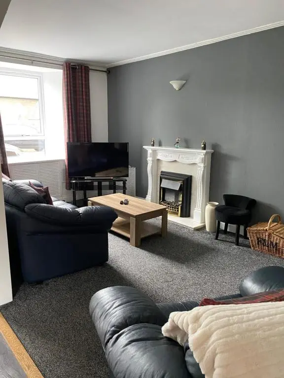 a living room with a couch and a fireplace at NC500, Wick Caithness Holiday Home in Wick