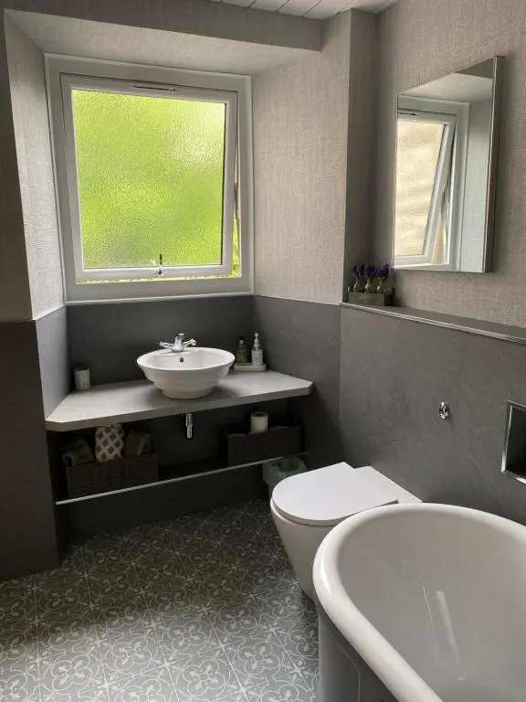 a bathroom with a sink and a toilet and a window at NC500, Wick Caithness Holiday Home in Wick