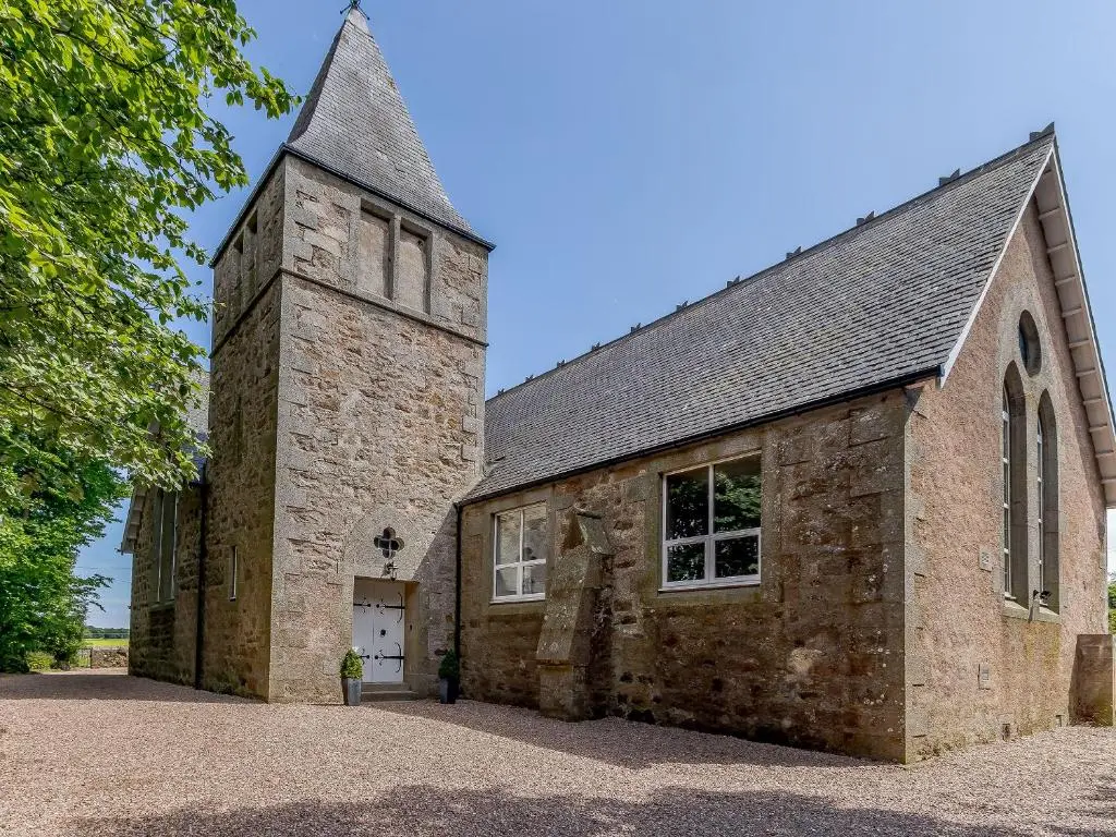 an old brick church with a tower and a door at Torreagles in Mintlaw