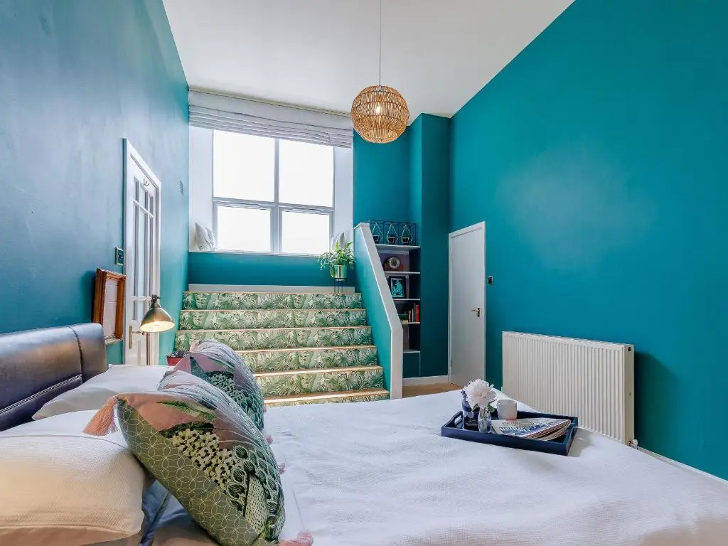 a bedroom with blue walls and a bed at Torreagles in Mintlaw