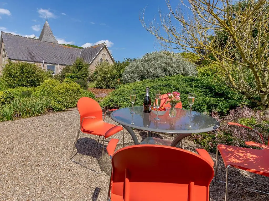 a table with red chairs and wine glasses on it at Torreagles in Mintlaw