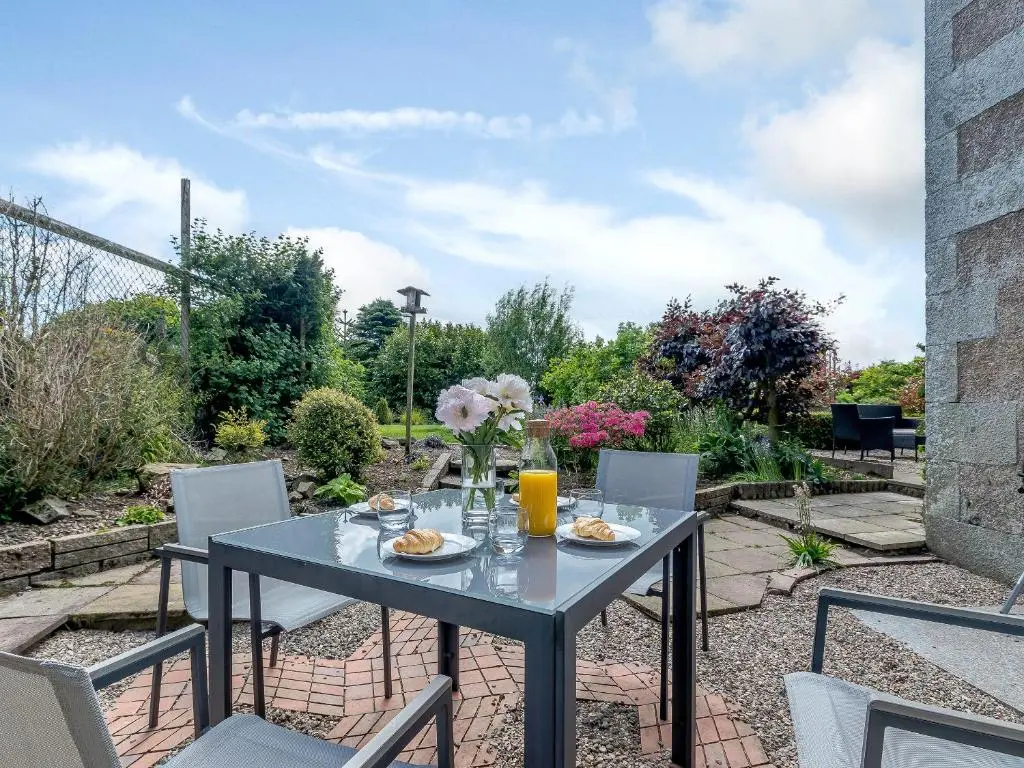 a table with a vase of flowers on a patio at Torreagles in Mintlaw