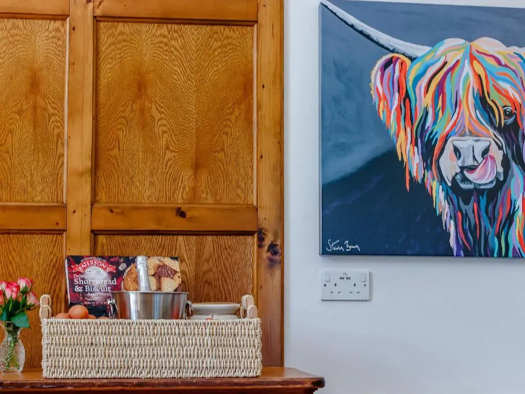 a painting of a dog on a wall next to a table at Torreagles in Mintlaw