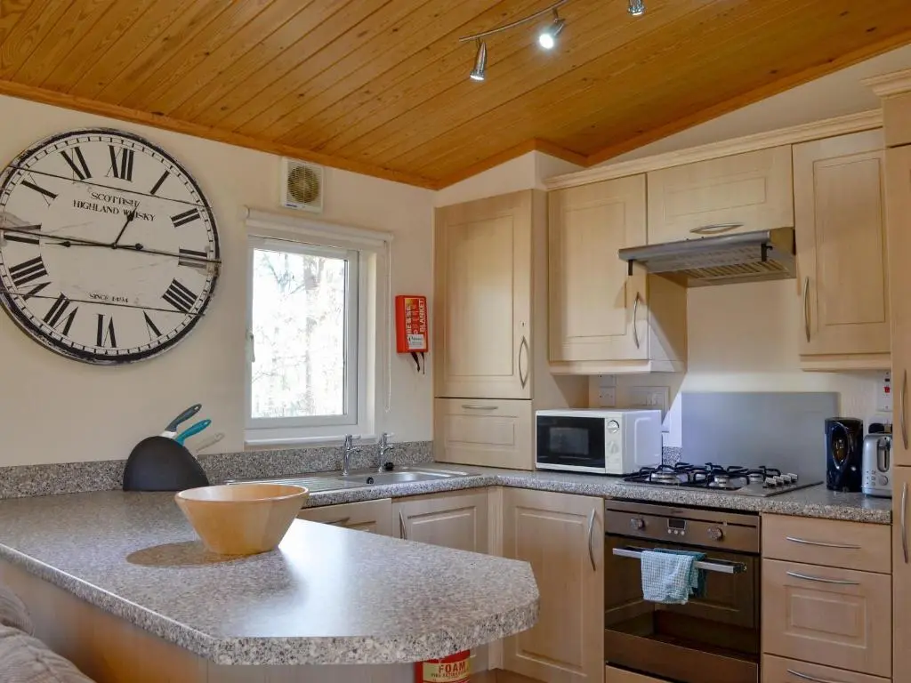a kitchen with a large clock on the wall at Lodge D- Uk33090 in Dinnet