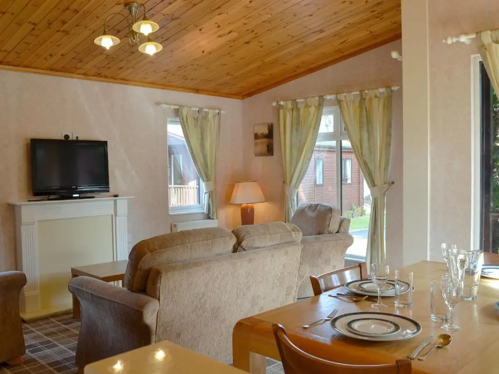 a living room with a couch and a table at Lodge A- Uk33088 in Dinnet