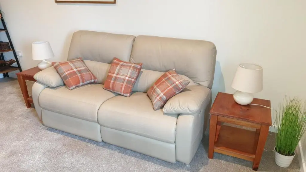 a couch with four pillows on it in a living room at Meadows 2 in Auldearn
